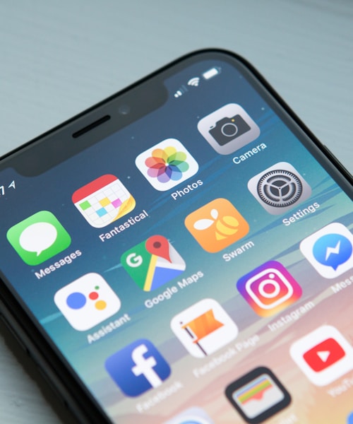 A hand holding a smartphone, with the screen softly lit